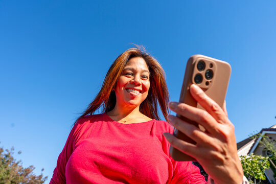 happy woman using mobile phone sky
