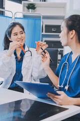 Medical team meeting analyzing blood test results in hospital laboratory. Doctors and scientists in lab coats are having a discussion about blood test result, holding test tubes and taking notes.