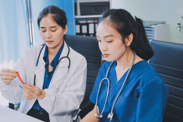Medical team meeting analyzing blood test results in hospital laboratory. Doctors and scientists in lab coats are having a discussion about blood test result, holding test tubes and taking notes.