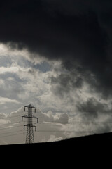 Electric power towers suppling cities and home throughout the world with electricity and Infrastructure with dramatic clouds and sky background