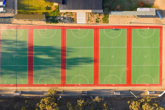 A row of green netball courts at a recreation reserve