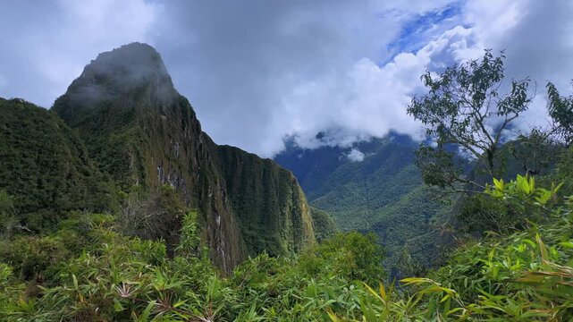 Huayna Picchu Quechua Mountain Machu Picchu prominent Peruvian Andes Peak Peru Per&uacute; aerial drone sunny blue sky clouds rainy season lush green jungle historic Inca Sanctuary landscape slide left