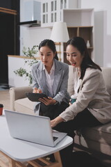Fototapeta premium Two businesswomen are having a productive meeting in the office. They are discussing business matters, signing a contract and shaking hands