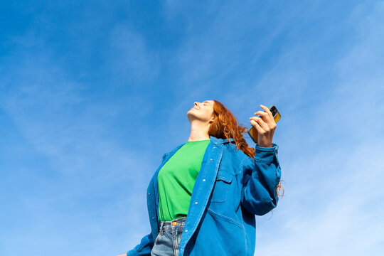 Happy woman with phone blue skye