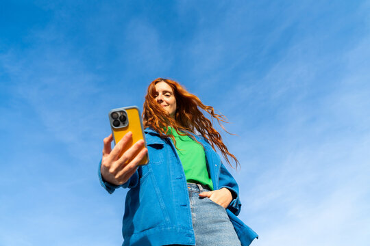 Happy woman with phone blue skye