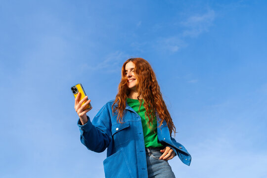 Happy woman with phone blue skye