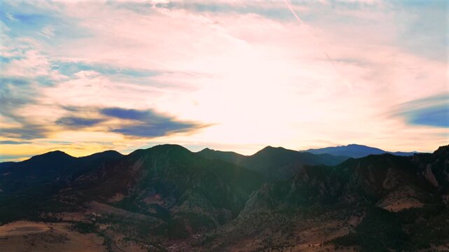 Winter Solstice December sunset golden hour Rocky Mountains Colorado aerial drone Front Range Eldorado Springs Canyon Green Mountain Flat Irons Chautauqua park clouds sun flare circle left motion