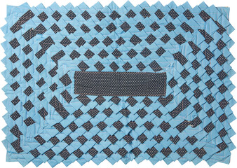 rectangular blue patchwork mat isolated white background, layered fabric strips with repeating serrated edge pattern and visible stitching in top view