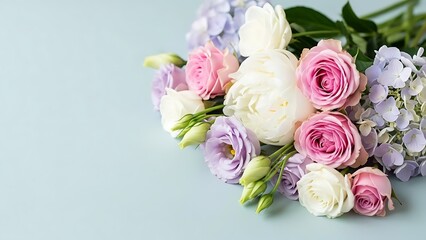 Pastel colored roses and lisianthus flowers bouquet on light blue background with hydrangeas