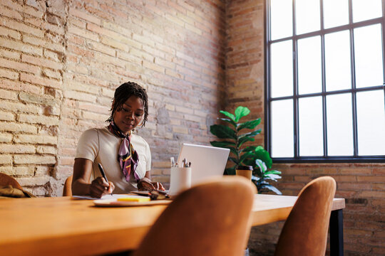 Woman writing notes in modern office