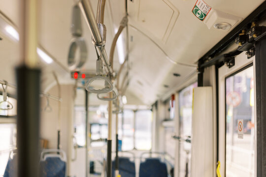 Interior View of a Public Bus Showing Seats and Overhead Handles