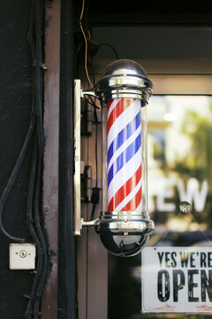 Red and Blue Barber Pole Signals Open Barbershop in the City