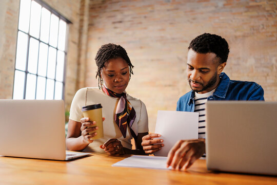 Colleagues collaborating on business documents in modern office