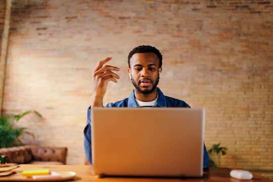 Man in earphones having video call on laptop