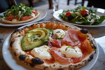 A photograph depicts various pizza and salad dishes arranged artistically on white plates in an Italian restaurant setting. One plate features tomato and avocado, while another is topped