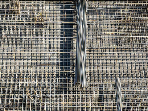 Overhead shot of dense steel rebar mesh on concrete slab