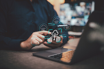 Person using smartphone and laptop with cloud computing icons overlay