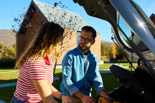 Man and woman pack their items into the trunk.