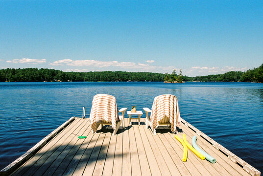 Summer lake dock with chairs, towels and floaties