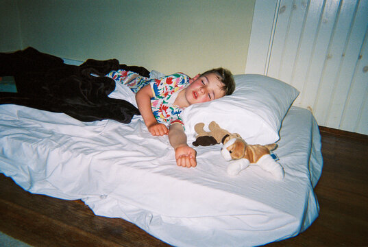 Child sleeping on mattress on the floor
