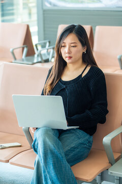 Chinese woman using laptop at airport