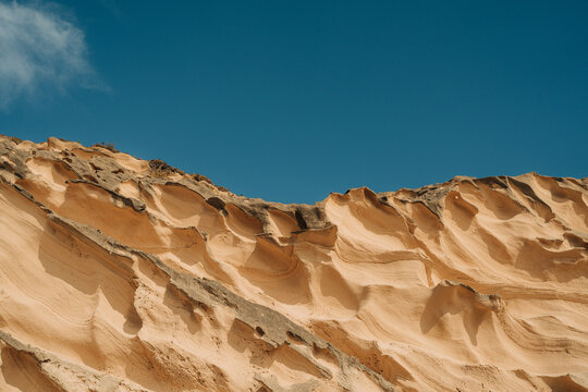 Rugged sandstone ridges at Magoito Beach cliffs