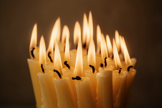 Group of Burning Candles Creating a Warm Glow in a Dark Setting
