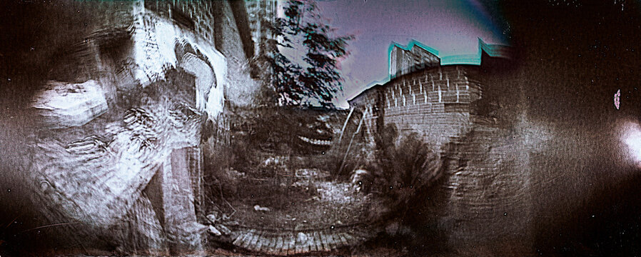 Old Abandoned Yard With Overgrown Plants and Fading Buildings