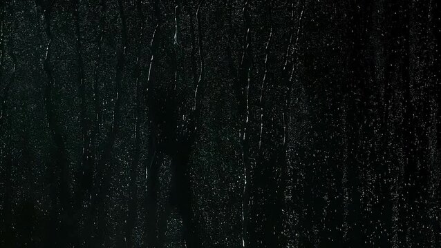 Water drops after the rain in a dark window | 4K Black Background