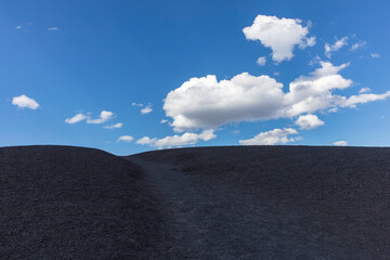 Mound of volcanic rock, clouds and sky above