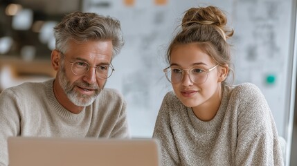 Middle aged man and young woman collaborate at a laptop discussing digital content and workflow.
Professional teamwork supports business consulting, education, and technology services.