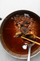 overhead view of fried goat meat in chopsticks, top view of fried mutton