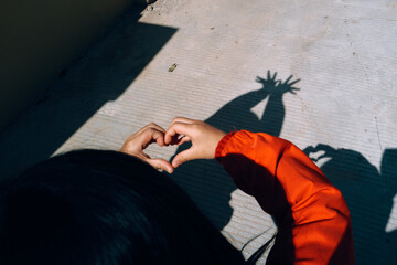 Creating Heart Shapes With Hands in Bright Sunlight