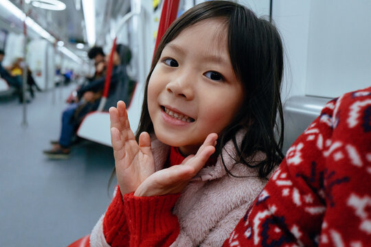 Child Enjoying a Ride on the Subway With a Cheerful Expression
