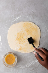 Overhead view of oil and flour mixture spread on raw chinese scallion pancakes dough, top view of homemade scallion pancakes, process of making cong you bing