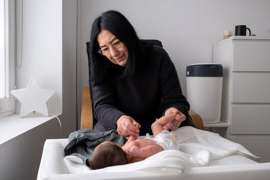 Older Woman Changing Newborn Baby&acirc;s Diaper At Home