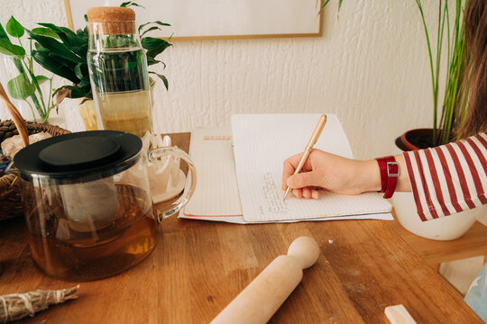 Tea and journaling moment in creative home studio with pottery t