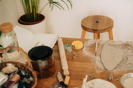 Artisan pottery workspace with tools, rolling pin and clay slab