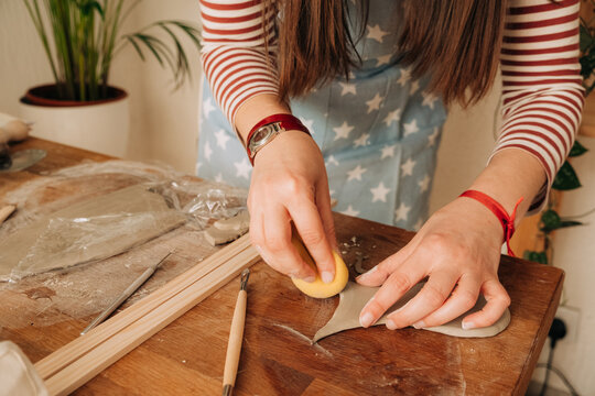 Smoothing clay surface with sponge in creative pottery process
