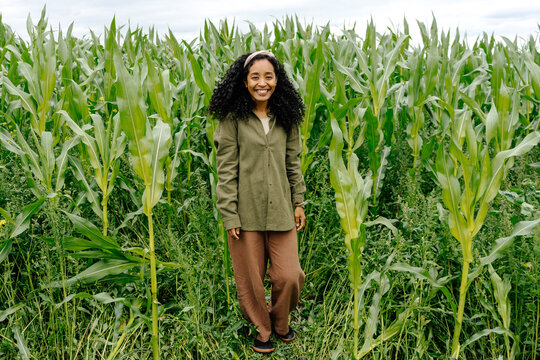 Person standing in green cornfield on organic farm