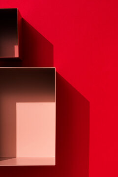 Empty boxes on red background under sharp light