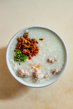 Malaysian rice porridge in white bowl on white table