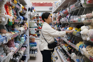 A woman shopping for yarn and crafting supplies in craft store