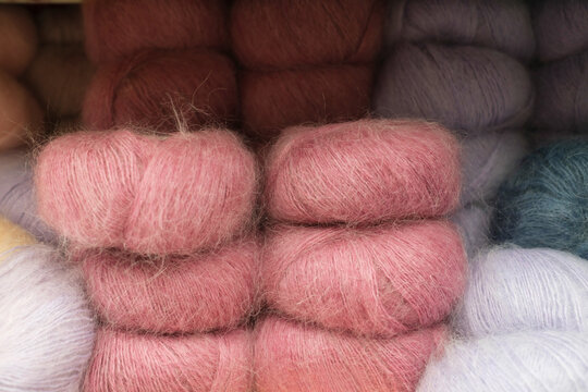 Soft and colorful yarn balls arranged neatly on display in a store