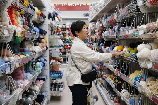 A woman shopping for yarn and crafting supplies in craft store
