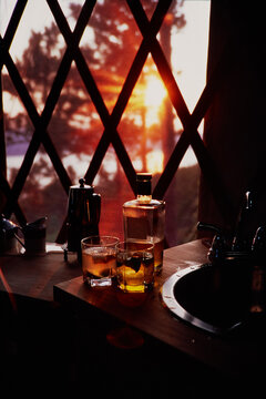 Two glasses of gin illuminated by the sunset light