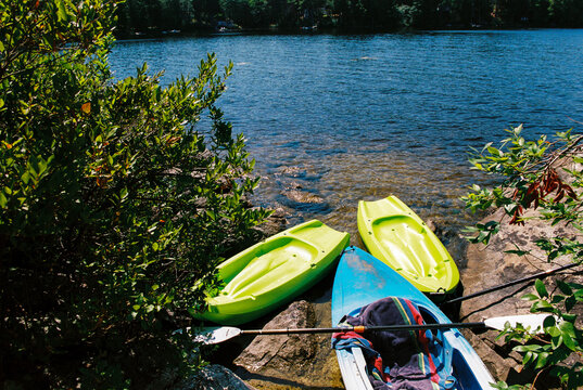 Three kayaks pulled up onto the shore