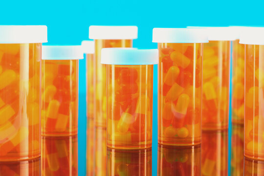  Capsules in Bottles Against Blue Background 