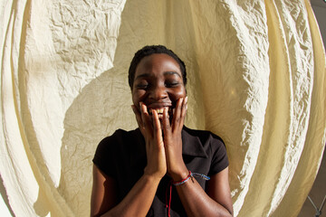 Joyful young woman smiling against a light background