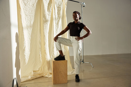 Creative studio model poses confidently in casual fashion setup